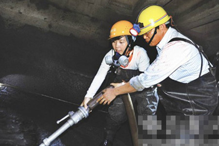 戴防毒面罩進行下水道清淤作業